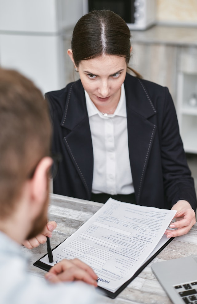 https://www.pexels.com/photo/a-woman-holding-a-document-talking-to-a-man-across-the-desk-7731399/